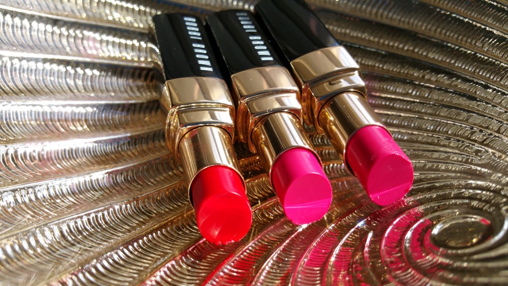 Left to right Bobbi Brown Nourishing Lip Colors in Poppy, Cosmic Peony, and Bright Raspberry