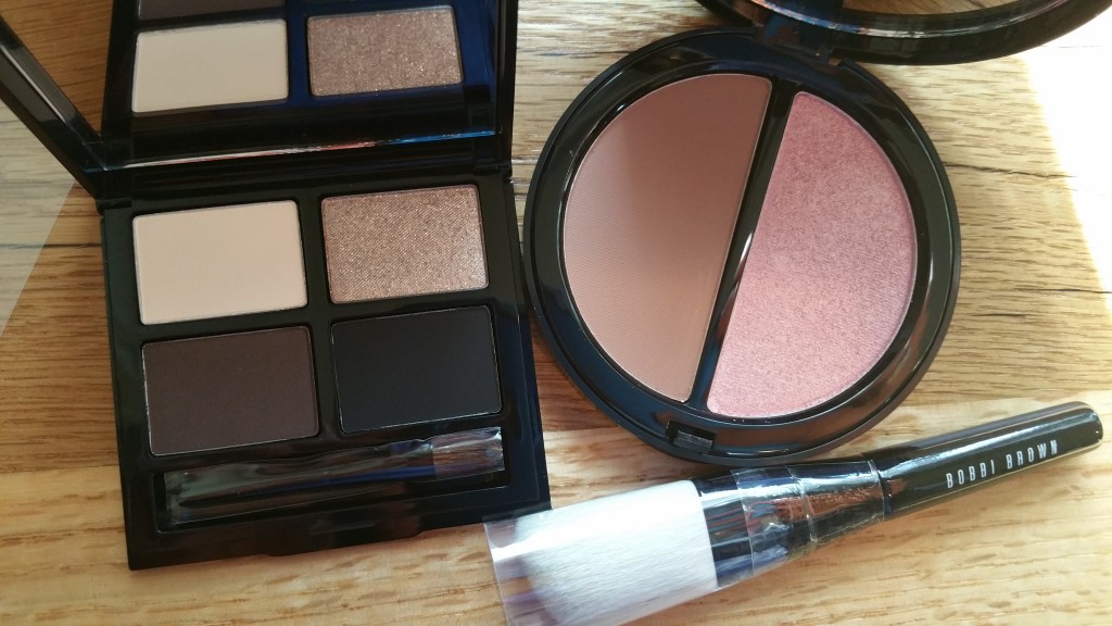 Bobbi Brown Cosmetics Define and Glow Set: Eyeshadow Palette, Bronzer/Highlighter compact, and mini Angled Face Brush.
